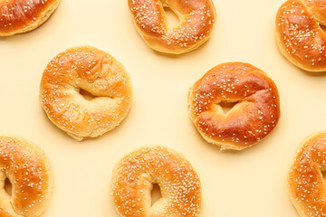 Tasty bagels with sesame seeds on beige background