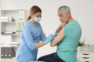 Obraz premium Doctor giving hepatitis vaccine to patient in clinic