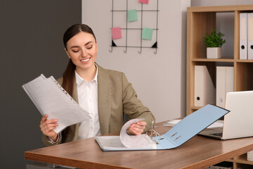 Businesswoman working with documents at wooden table in office