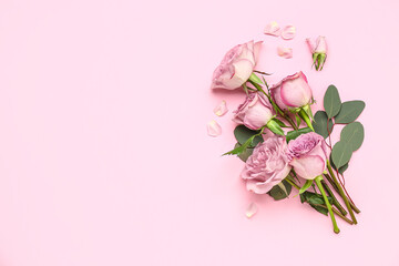 Beautiful roses with eucalyptus branches on pink background