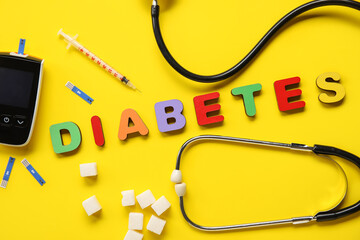 Word DIABETES with sugar, glucometer and syringe on yellow background