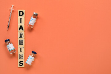 Word DIABETES with insulin and syringe on red background