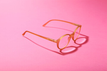 Glasses with corrective lenses on bright pink background