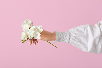 Woman with white flowers on pink background. Hand care concept