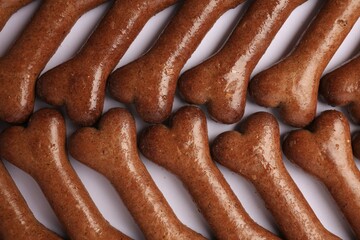 Flat lay composition with many bone shaped dog cookies on white background