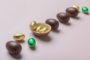 Sweet chocolate Easter eggs and candies on light background