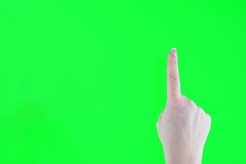 Index finger on a green background Woman finger and hand and touching on green screen background. High quality photo