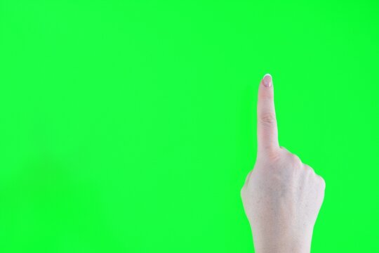 Index finger on a green background Woman finger and hand and touching on green screen background. High quality photo - Powered by Adobe