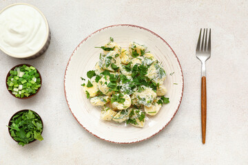 Plate of tasty Potato Salad with greens on light background
