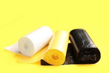 Different rolls of garbage bags on yellow background