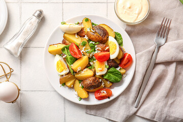 Plate of tasty potato salad with eggs and tomatoes on light background, top view