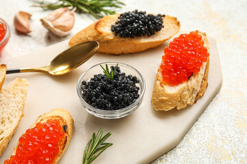 Tasty bruschettas with red and black caviar on light grunge background