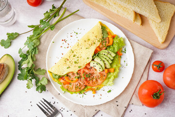 Tasty omelet with vegetables on light table