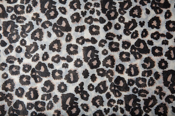 White fabric with leopard print, black and brown.