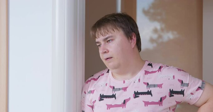 Man in funny pink pajamas dogs woke up early in the morning, looks disapprovingly and shakes his head sighs. Get up early weekend lazy mood. Infantile bored sleepy man in a bad mood. Parenting