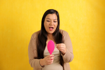 Latin adult woman with very long straight hair suffers from hair loss looking at the brush how many...