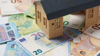 Concept of home ownership. New house and Euro money as a background. Invest in real estate