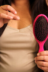 Latin adult woman with very long straight hair suffers from hair loss looking at the brush how many...