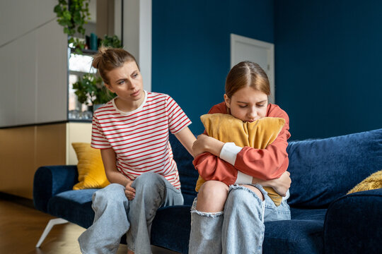 Mother supporting child upset teen girl during difficult adolescence stage, loving parent comforting child at home. Sad teenage daughter crying and feel anxious, being bullied at school