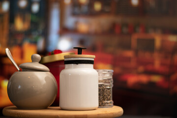 Mugs of sugar and containers and a spoon vintage over a table in night restaurant and copy space