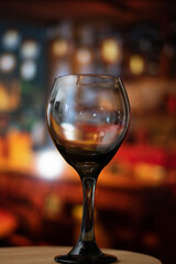 Vertical view of close up of empty glass of wine in a vintage bar over a table and copy space