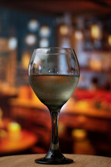 Vertical view of Close up of glass of wine filled of rose wine in vintage bar and copy space