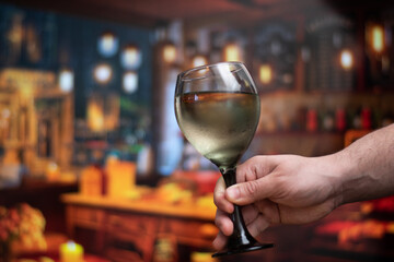 Close up of hand holding a cup of wine with copy space and bokeh in background