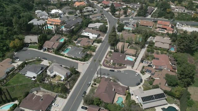 A neighborhood of single-family homes is shown near Glendale, California during a sunny, spring day in an aerial flyover view.