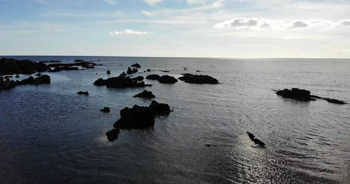 Aerial drone shot captures reflective water and coastline rocks, Thurlestone, South Devon England UK