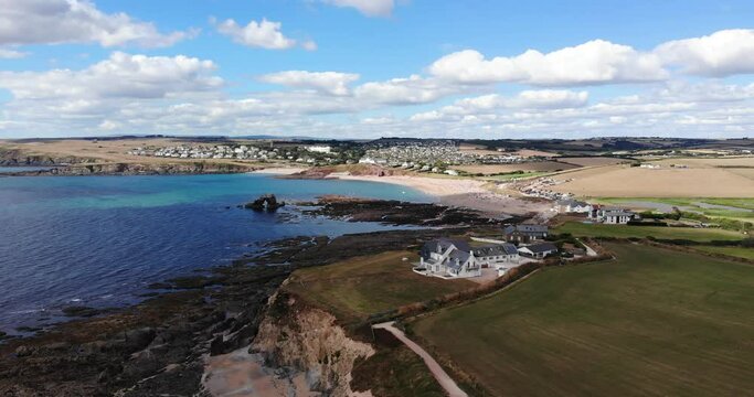 Thurlestone, England Village. Aerial shot flying sideways over beautiful coastline with clouds in blue sky.