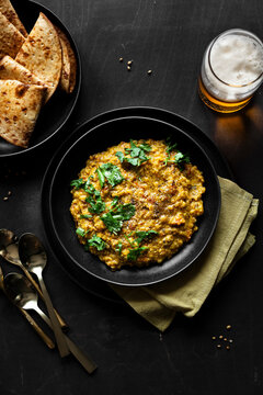 Overhead View of Indian Tarka Dal Curry with Roti, Beer and Cilantro