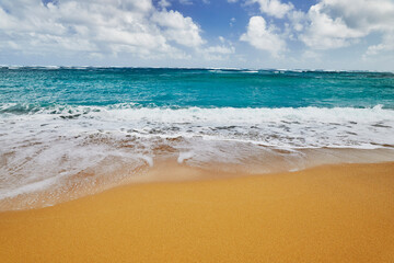 Ocean waves breaking onto a sand beach