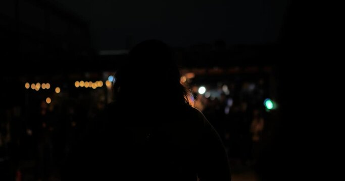 Woman looking at fire show back of woman