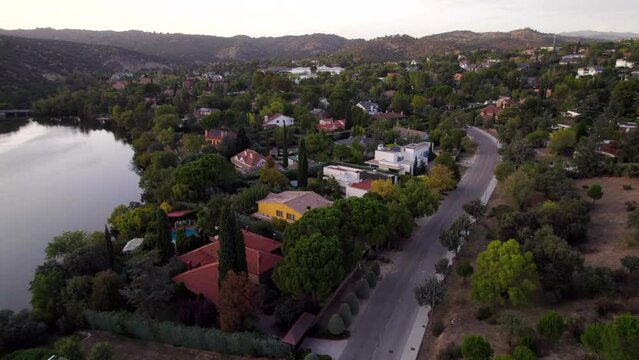 Drone flying over los Peñascales wealthy private villas complex close to a lake in Madrid, Spain
