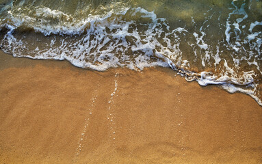 Ocean waves breaking onto a sand beach