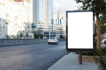 Vertical billboard near the road in the city. Free road, city center. Mock-up.