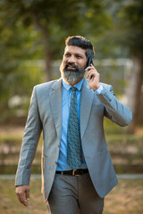 Indian businessman talking on smartphone at outdoor.