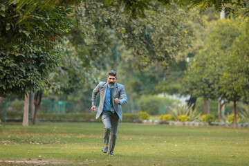 Indian corporate man running at park.