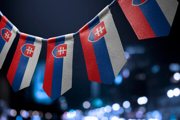 A garland of Slovakia national flags on an abstract blurred background