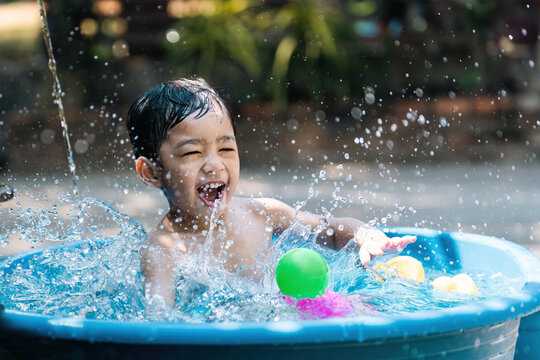 Asian children playing in a small pool in summer