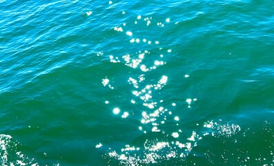 Sunbeams on the emerald green waters of the Pacific Ocean glisten in the sun background for any text travel advertising congratulations vacation trip holidays. High quality