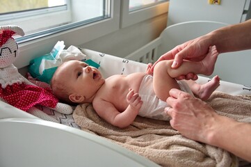 Father changing diapers of cute little baby girl