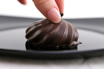 delicious dessert Marshmallows in chocolate on black plate female hand takes his lunch homemade handmade beautiful restaurant serving Reflection close-up advertising confectioner courses life is good