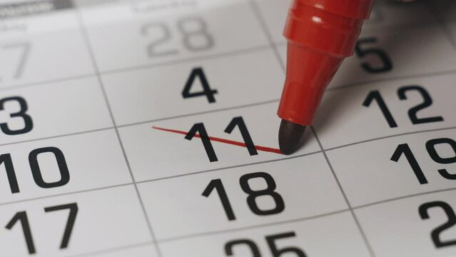 The eleventh in the calendar is boldly crossed out with a red marker as an important event completed. Close-up.