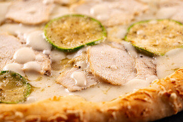 Closeup on chicken pizza with zucchini and cheese