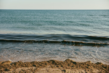 seascape with rolling waves on a calm, sunny day at sunset