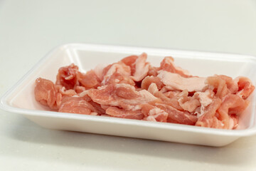 白いプラスチックトレイの上の赤い豚肉