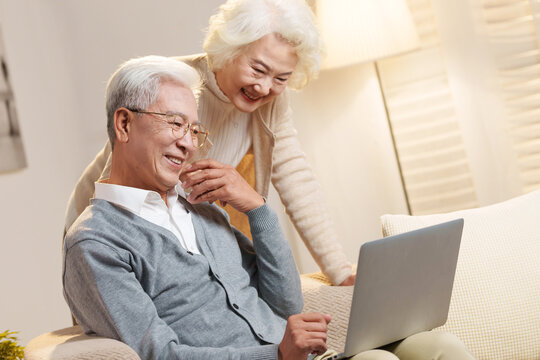 Elderly couple using laptops