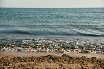 seascape with rolling waves on a calm, sunny day at sunset