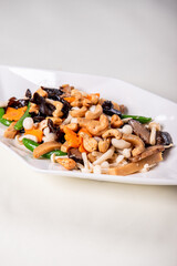 stir fried white shimeji mushroom with scallop black fungus cashew nut deep fried yam bean curd and mixed colourful vegetables on wood table asian Chinese vegan halal food banquet menu for restaurant
